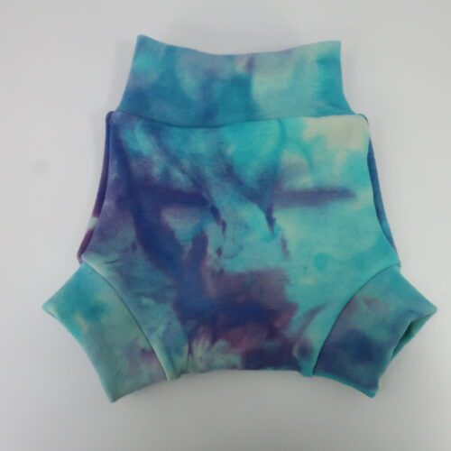 Our Brief Fit Wool Diaper Cover. This cover is a bit taller and more trim fitting that our Traditional style of cover. The leg cuffs are also small/tighter and longer. This cover is a tie dyed blue and purple.