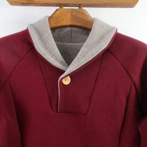 Unisex Adult Campfire Sweater. Merino Wool. Sweater with a fold over collar, possibly two toned, with a button closure. Wine red colour with a light brownie/grey melange on the inside of the collar.