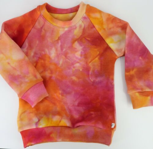 Merino Wool Simple Crew Neck Sweater. With cuffed raglan sleeves and a classic rounded crew neck. This sweater is a tie dyed orange/pink/yellow colour.