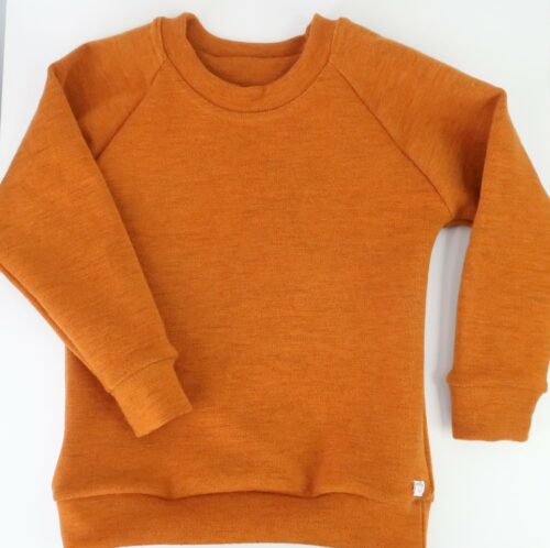Merino Wool Simple Crew Neck Sweater. With cuffed raglan sleeves and a classic rounded crew neck. This sweater is a burnt orange colour.
